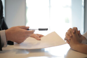 person handing a paper to another person