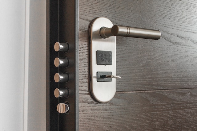 Brown door with a silver handle and multiple locks
