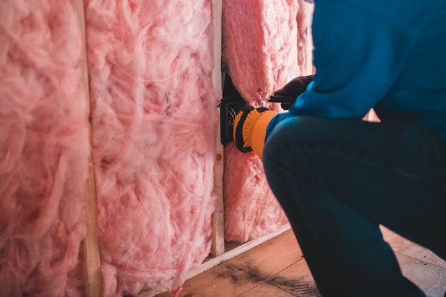 Cropped worker insulating with pink stone wool