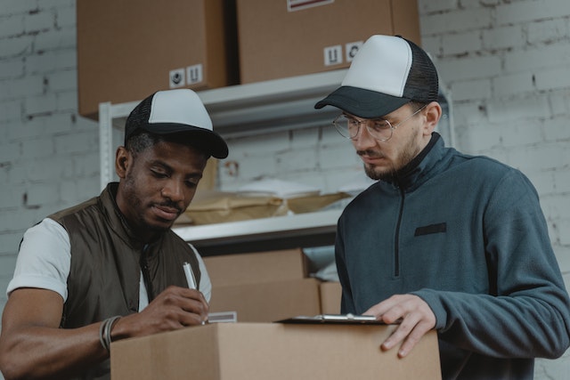 Two people going over a form while surrounded by letters and packages