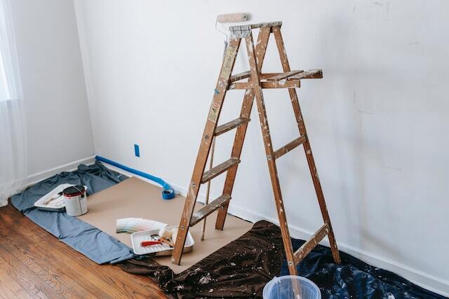 a-ladder-and-paint-supplies-set-up-against-a-wall