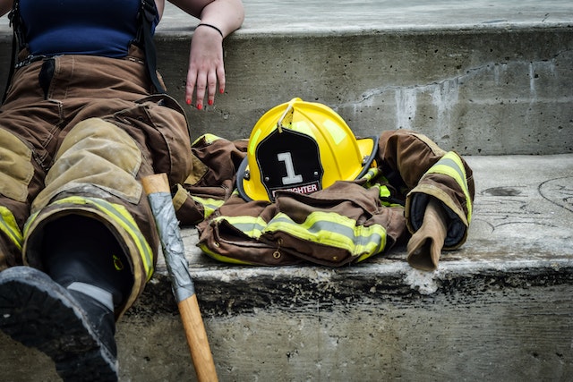 firefighter-sitting-down-on-some-steps-with-their-hat-and-jacket-next-to-them