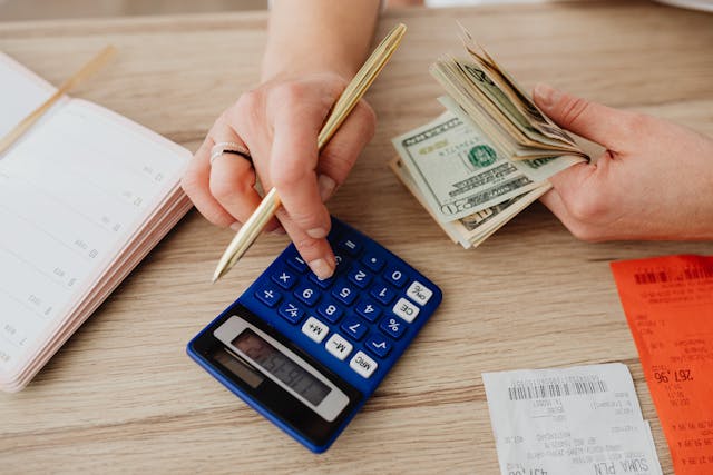 person-calculating-money-and-receipts-using-a-calculator