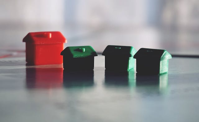 toy-properties-arranged-to-be-in-a-neighbourhood-with-one-larger-red-house-and-three-green-smaller-houses