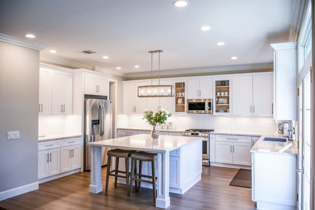 a-modern-kitchen-with-white-cabinets-stainless-steel-appliances-and-a-central-island-with-barstools