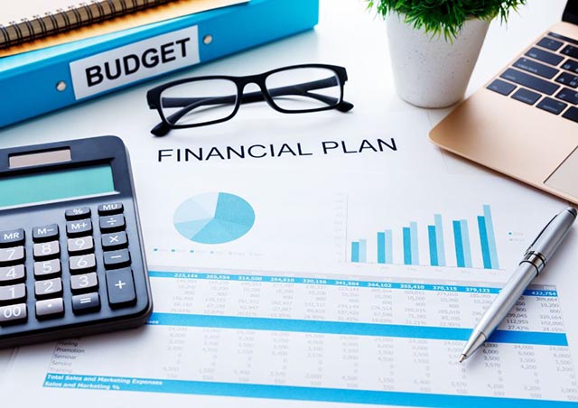 paper-with-financial-plan-written-on-it-with-graphs-and-charts-a-calculator-pen-glasses-and-laptop